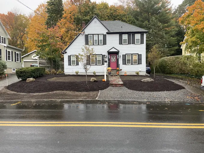 A finished front yard with fresh mulch beds seen from the street