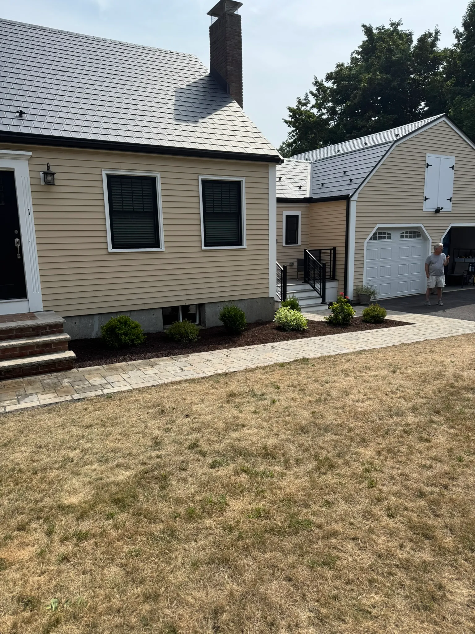 A completed front-yard bed and clean grade in front of a renovated home