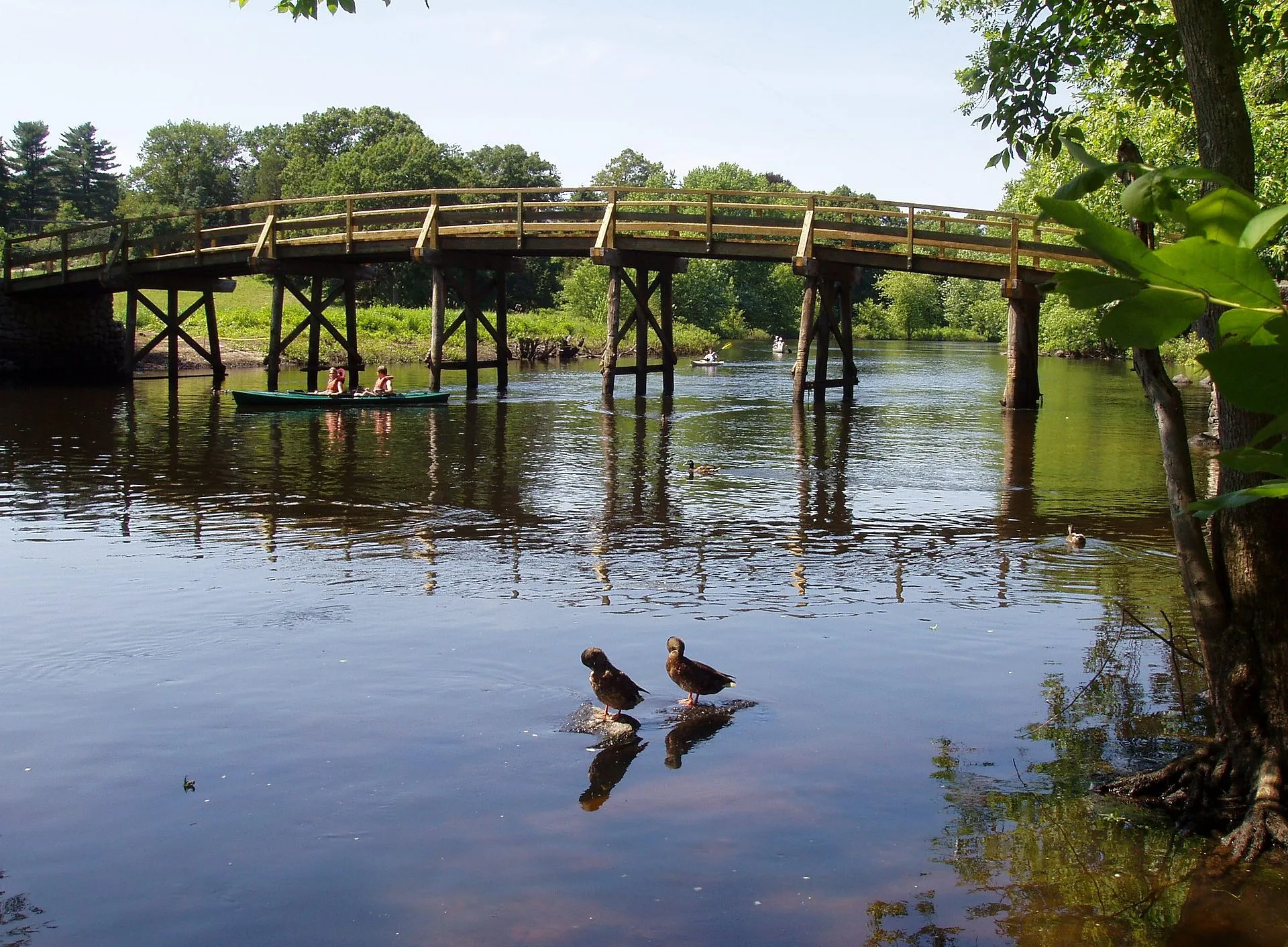 The Old North Bridge over the Concord River in summer, with reflections and lush greenery