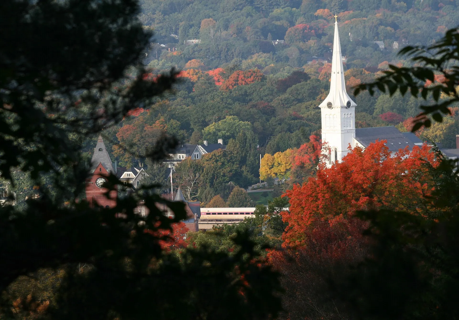 Winchester town center framed by fall foliage with its white church steeple and brick clock tower